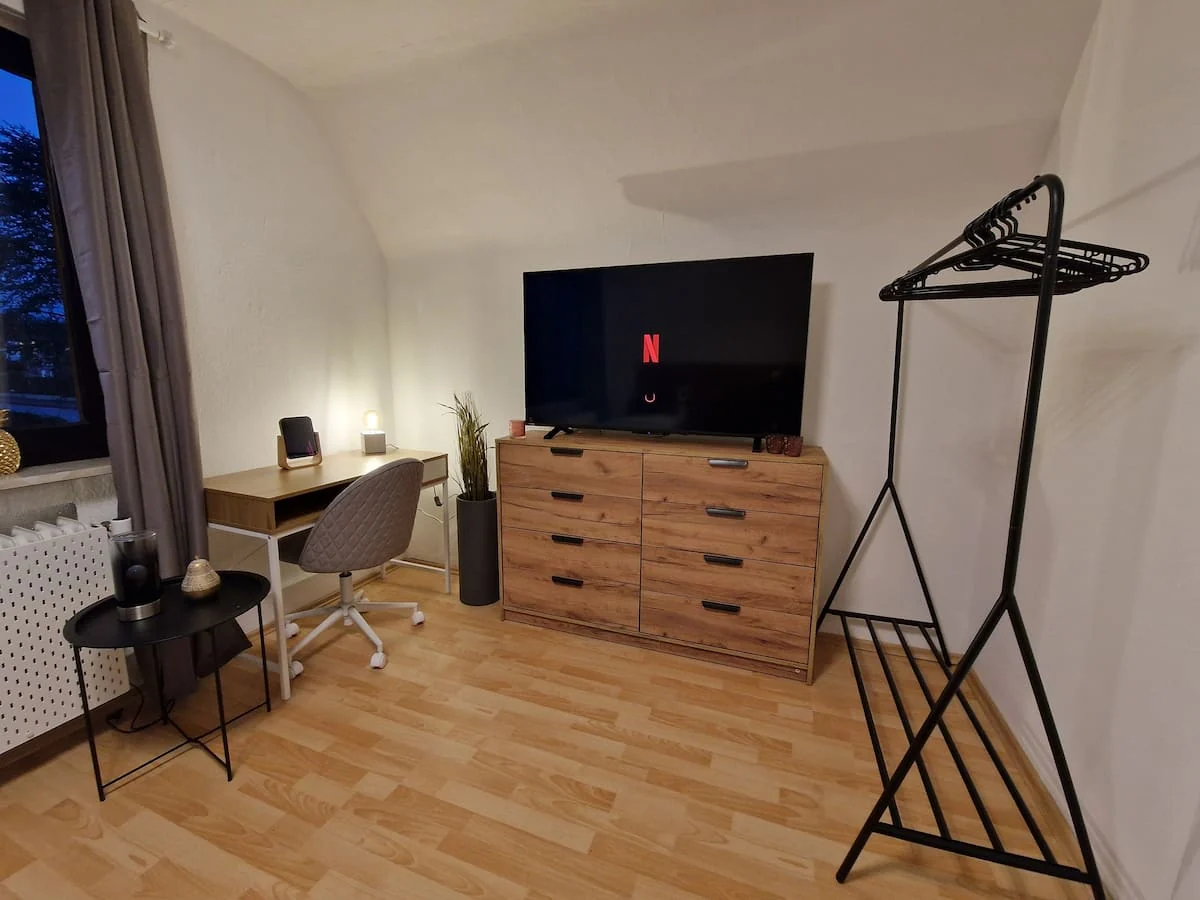 Schlafzimmer mit Arbeitsplatz und Fernseher im Obergeschoss